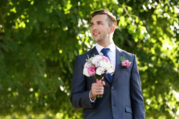 Groom holding wedding bouquet — Stock Photo, Image