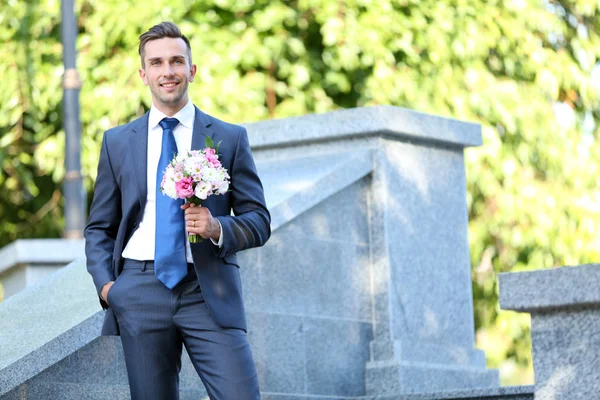 Groom holding wedding bouquet — Stock Photo, Image