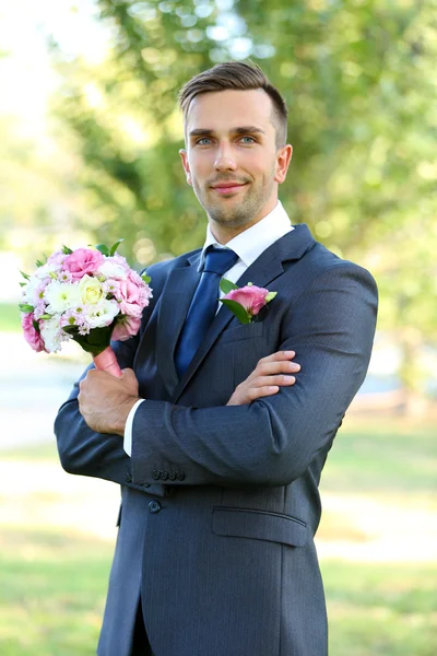 Groom holding wedding bouquet — Stock Photo, Image