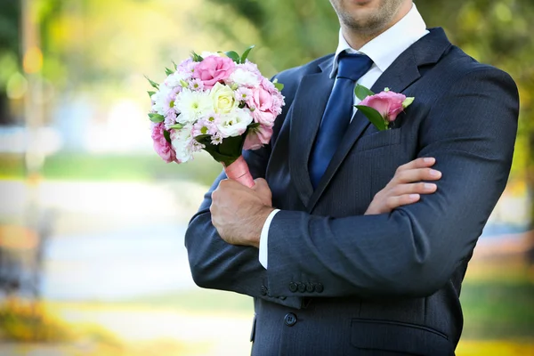 Bräutigam hält Brautstrauß im Freien — Stockfoto