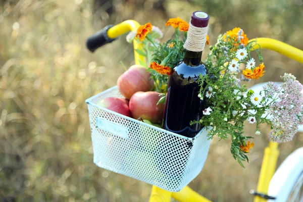 Cykel med blommor och en flaska vin i metall korg närbild, utomhus — Stockfoto