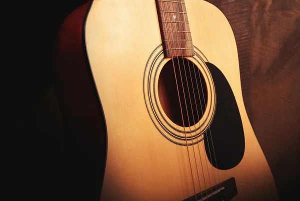 Gitarre auf hölzerner Wand Hintergrund Nahaufnahme — Stockfoto