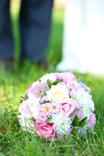 Wedding bouquet on grass of couple background Royalty Free Stock Photos