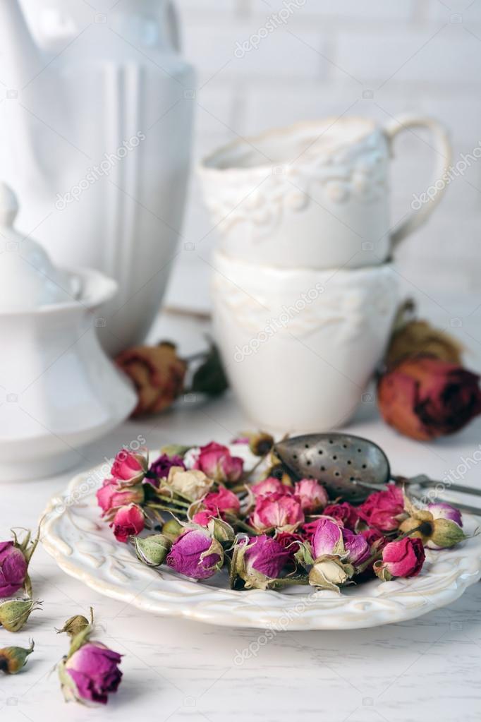 Tea set and tea rose flowers on table