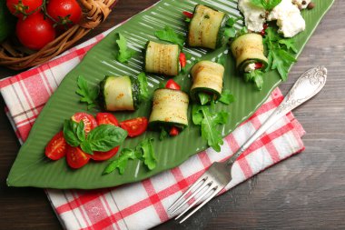 Kabak rulo peynir, biber ve roka ile tabağında, yakın çekim, tablo arka plan üzerinde