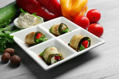 Kabak rulo peynir, biber ve roka ile tabağında, yakın çekim, tablo arka plan üzerinde