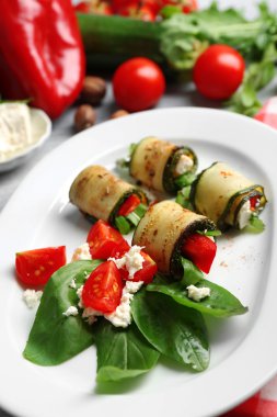 Kabak rulo peynir, biber ve roka ile tabağında, yakın çekim, tablo arka plan üzerinde