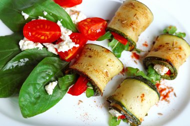 Kabak rulo peynir, biber ve roka ile tabağında, yakın çekim, tablo arka plan üzerinde