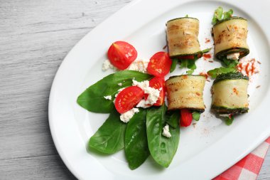 Kabak rulo peynir, biber ve roka ile tabağında, yakın çekim, tablo arka plan üzerinde