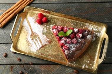 Kek çikolata sır ve ahududu ahşap arka plan üzerinde tepsi