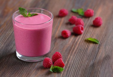 Ahşap arka plan üzerinde çilek ile Ahududu milkshake bardak