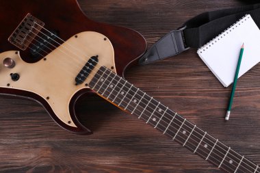 Elektro gitar ahşap masa üstünde defter ile yakın çekim