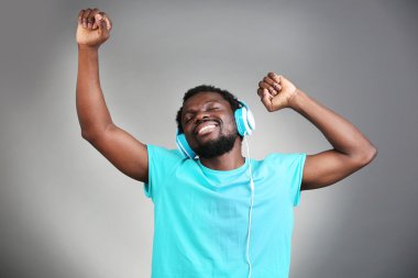 Afrika kökenli Amerikalı adam gri arka plan üzerinde kulaklık ile