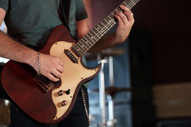 Genç adam elektro gitarla oynuyor. Yakın plan.
