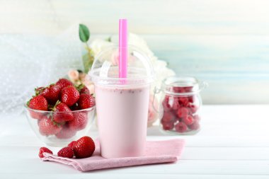 Milkshake hafif ahşap arka plan üzerinde plastik bardak