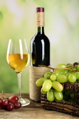 Şarap şişesi ile sepette beyaz üzüm demet