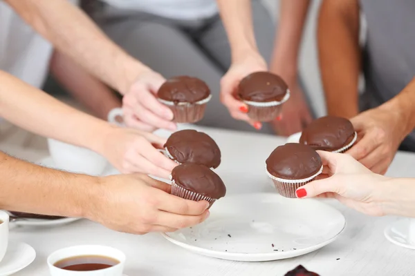 Vrienden handen met desserts en kopjes thee, close-up — Stockfoto