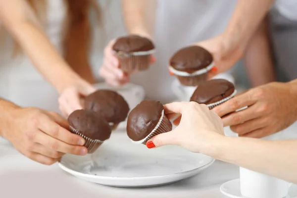 Vrienden handen met desserts en kopjes thee, close-up — Stockfoto