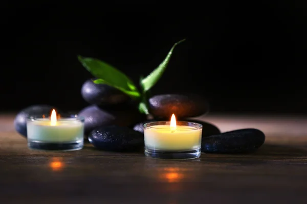 Wellness-Steine und Kerzen auf dunklem Hintergrund — Stockfoto
