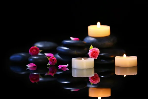 Piedras de spa y velas sobre fondo oscuro — Foto de Stock