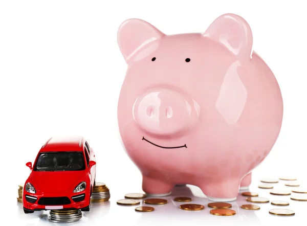 Свинка банка с автомобильной игрушкой и монеты вокруг, изолированные на белом — стоковое фото