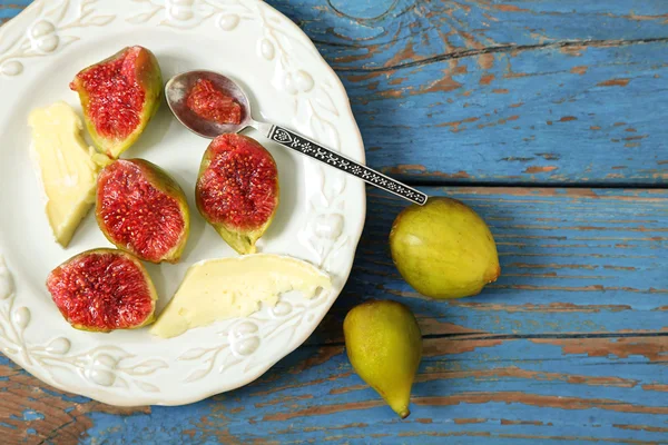 Ripe figs on plate, on color wooden background — Stock Photo, Image