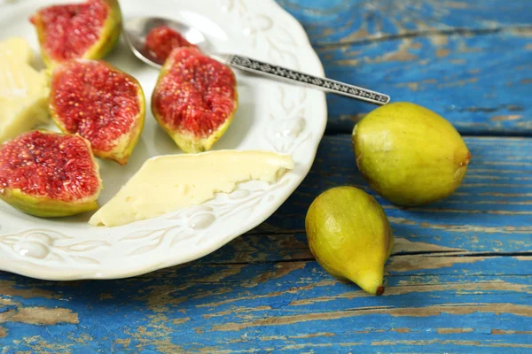 Ripe figs on plate, on color wooden background — Stock Photo, Image