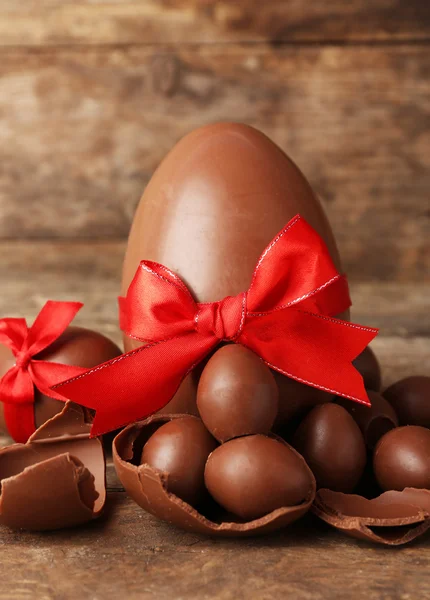 Un chocolate grande y pequeño Huevos de Pascua sobre fondo de madera — Foto de Stock