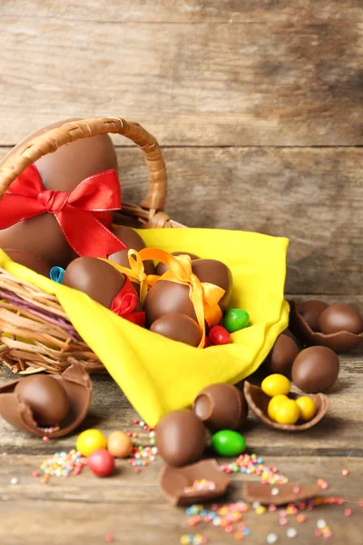 Huevos de Pascua de chocolate en cesta sobre fondo de madera — Foto de Stock