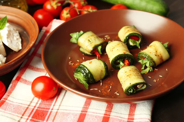 Zucchini rolls with cheese, bell peppers and arugula on plate, close-up — Stock Photo, Image