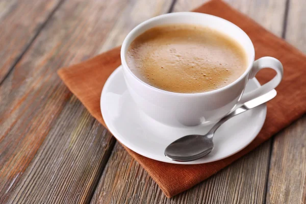 Secangkir kopi pada tutup serbet coklat — Stok Foto