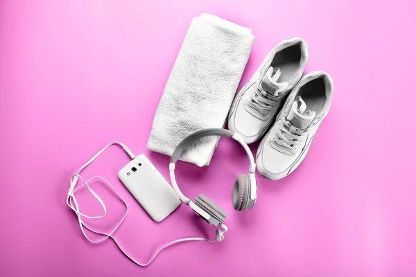运动鞋、 毛巾和耳机在粉红色的背景上 — 图库照片