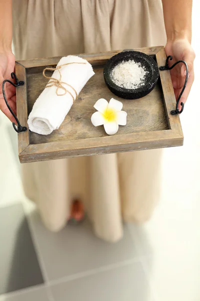 Mani femminili con vassoio di prodotti spa, presso il salone spa — Foto Stock