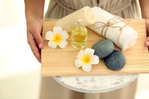 Manos femeninas con bandeja de productos de spa, en el salón de spa — Foto de Stock