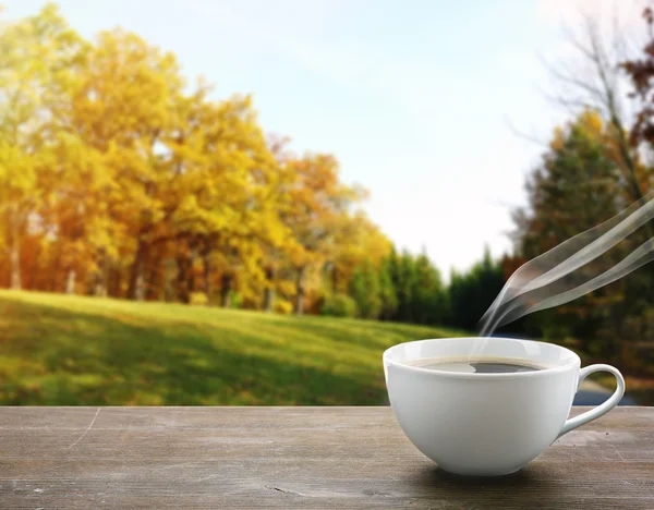 Kopp kaffe på bordet på natur bakgrund — Stockfoto
