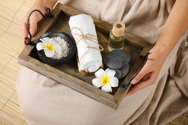 Manos femeninas con bandeja de productos de spa, en el salón de spa — Foto de Stock