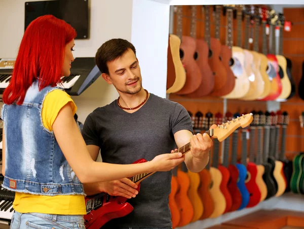 Bella giovane coppia nel negozio di musica — Foto Stock