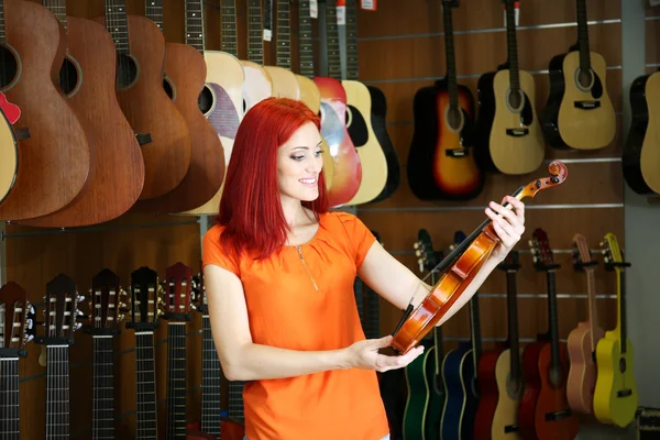 Bella giovane donna nel negozio di musica — Foto Stock