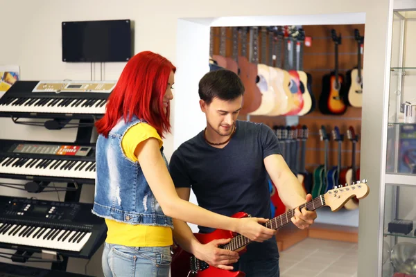 stock image Beautiful young couple in music store