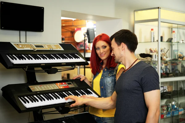 Hermosa pareja joven en la tienda de música —  Fotos de Stock