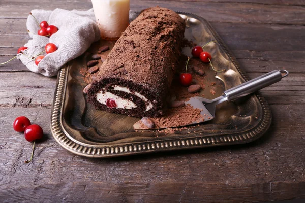 Rolo de chocolate com creme e bagas na mesa de perto — Fotografia de Stock