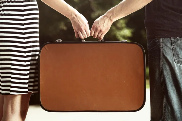 Young couple holding vintage suitcase outdoors — Stock Photo, Image