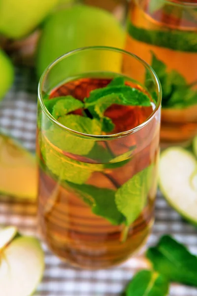 Vasos de jugo de manzana con frutas y menta fresca en la mesa de cerca —  Fotos de Stock