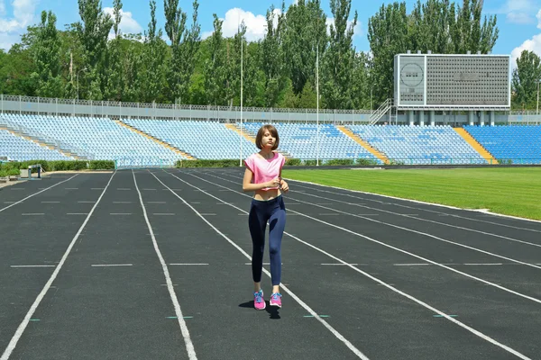 Молодая женщина бегает по стадиону — стоковое фото