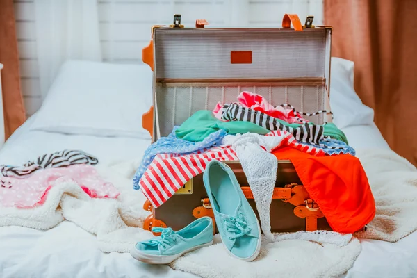 Maleta con ropa en la cama en la habitación — Foto de Stock