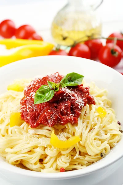 Espaguete com molho de tomate e queijo na placa branca, na cor de fundo de madeira — Fotografia de Stock