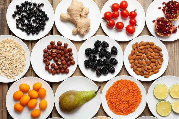 Different products on saucers on wooden table, top view — Stock Photo, Image