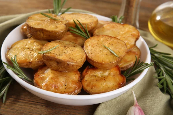 Deliciosa papa al horno con romero en tazón en la mesa de cerca —  Fotos de Stock