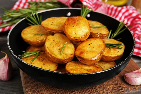 Delicious baked potato with rosemary in frying pan on table close up — Stock Photo, Image