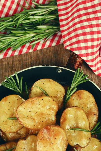Leckere Ofenkartoffeln mit Rosmarin in der Pfanne auf dem Tisch aus nächster Nähe — Stockfoto